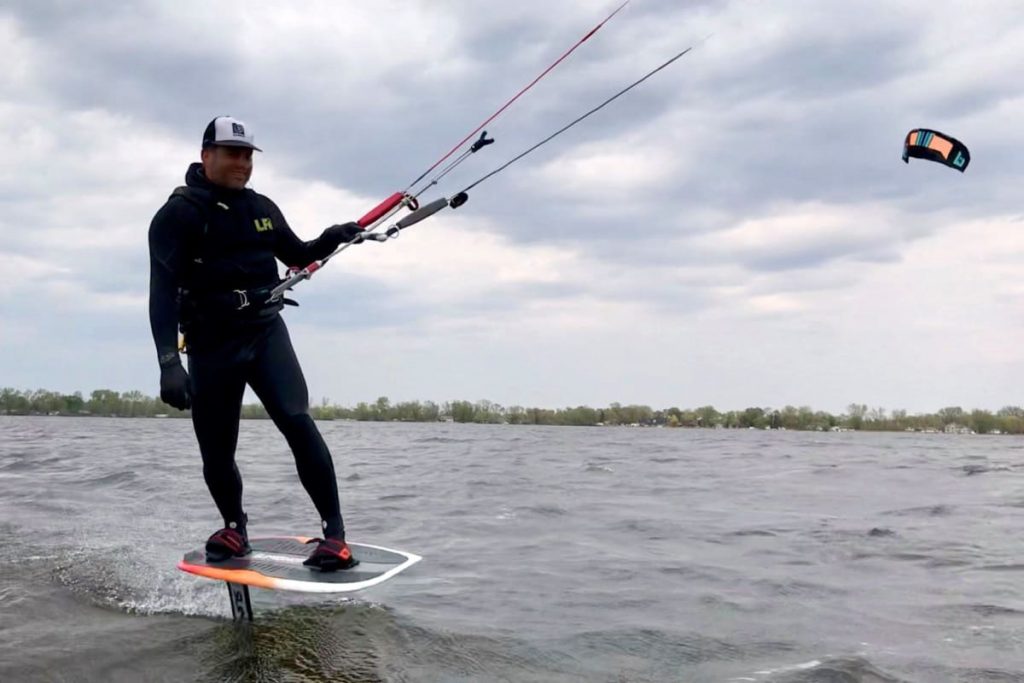 A foilboarder gets close to the camera on a windy lake